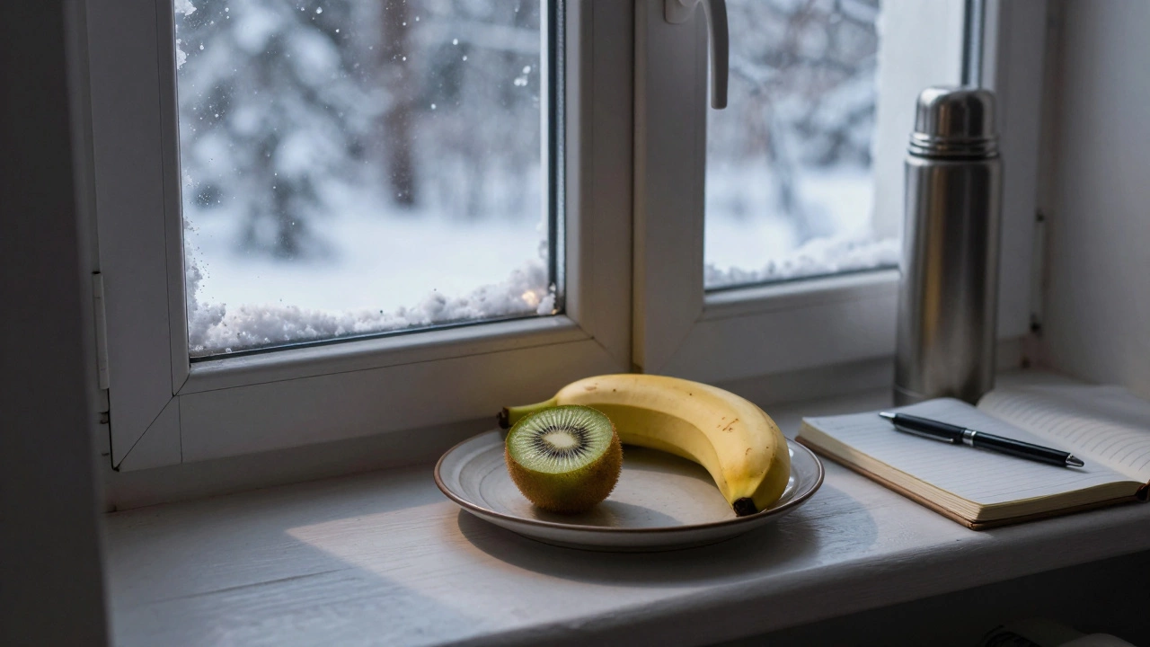 Киви и половина банана на тарелке у окна зимним вечером.